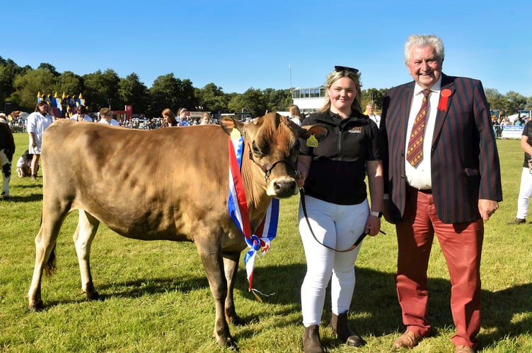 David Morgan presents the award for champion dairy cow  to Nina Pryce with Daisy