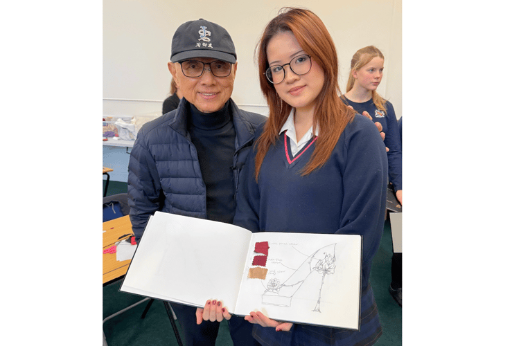 A pupil shows her design to Jimmy Choo